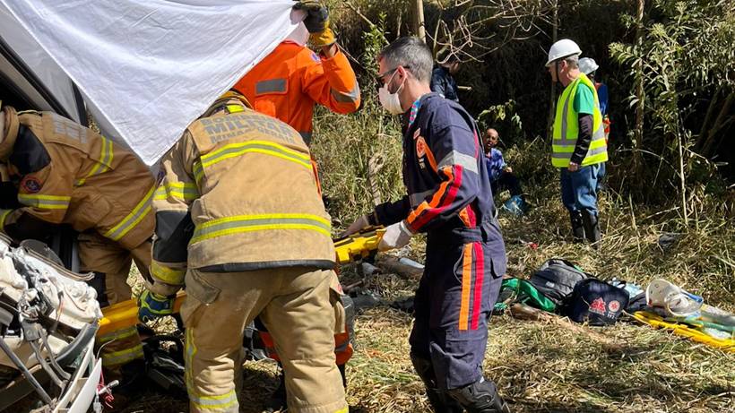 Carreta com madeira tomba em estrada rural e motorista fica preso às ferragens